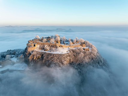 Aerial view of the Hegau volcano Hohentwiel with Germany's largest fortress ruins on a cold, foggy