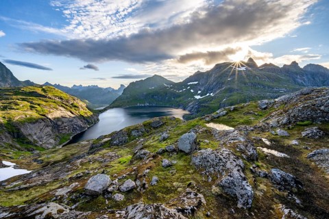 Mountain landscape with lake Tennesvatnet, at sunrise with sun star, Moskenesoya, Lofoten,