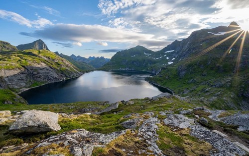 Mountain landscape with lake Tennesvatnet, at sunrise with sun star, Moskenesoya, Lofoten,
