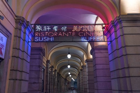 Nocturnal illuminated advertising in the historic arcade at the harbour, Genoa, Italy, Europe