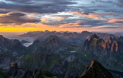 View over mountain top and sea, dramatic sunset, from the top of Hermannsdalstinden, Moskenesöy,