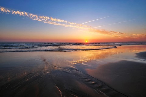 Atlantic ocean sunset with surging waves at Fonte da Telha beach, Costa da Caparica, Portugal,