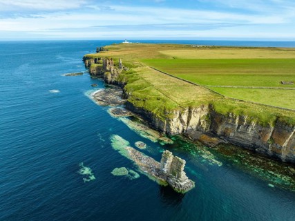 Rugged rocky landscape on the North Sea coast with the ruins of Girnigoe and Sinclair Castle, Wick,
