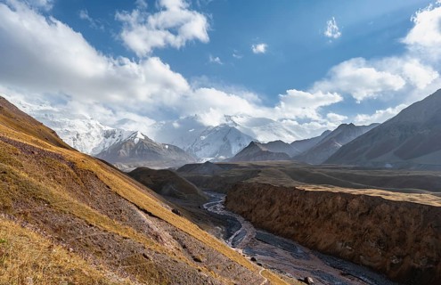 Valley with river Achik Tash between high mountains, mountain landscape with glaciated peak Pik