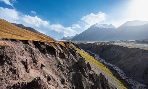 Valley with river Achik Tash between high mountains, mountain landscape with glaciated peak Pik