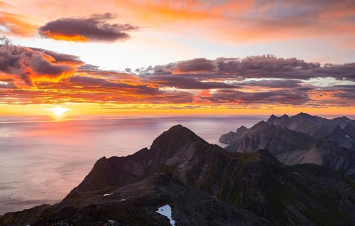 View over mountain top and sea, dramatic sunset, from the top of Hermannsdalstinden, Moskenesöy,
