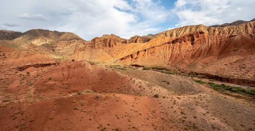 Eroded mountain landscape with sandstone cliffs, red and orange rock formations, Konorchek Canyon,