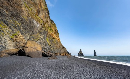 Black beach with cliffs, rock Reynisdrangar in the water, at Reynisfjara beach, Vik, South Iceland,