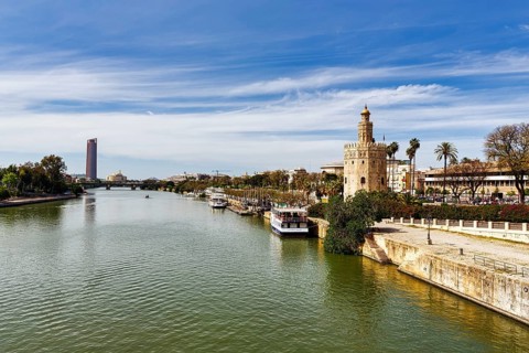 View over the Rio Guadalquivir with Torre del Oro and riverside promenade, Torre Sevilla in the