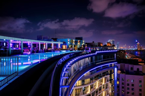 Night shot rooftop pool, swimming pool, Dubai Marina skyline behind, Hotel NH Collection The Palm