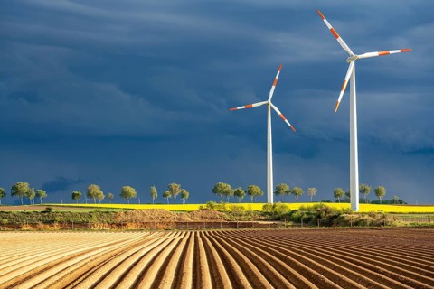 Wind turbines on a rape field, dark rain clouds, in the Rhenish lignite mining area, near