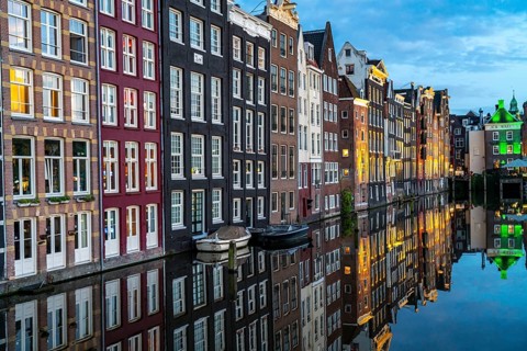 Canal houses on the Damrak, in the centre of the old town of Amsterdam, harbour, starting point of