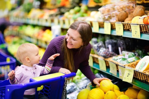 A young mother goes shopping with her baby in the supermarket, Scandinavia
