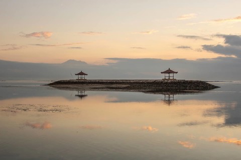 Beautiful seascape in the morning. Tropical sandy beach with breakwater and reflection of the sky