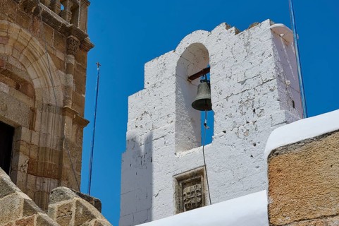 A striking bell tower made of white stones under a bright blue sky in Mediterranean architecture,