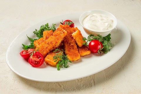 Fried fish nuggets, with white sauce, arugula and cherry, no people