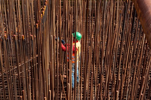 Construction site, reinforced concrete construction site, workers erect a mesh of reinforcing bars,