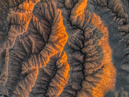 Landscape of eroded hills at Lake Issyk Kul, top-down, badlands at sunrise, aerial view, Canyon of