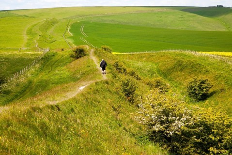 Two men walking along the ditch and embankment of the Wansdyke a Saxon defensive structure on All