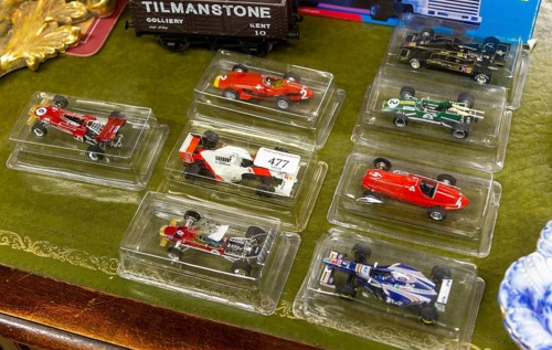 Boxed model racing cars in clear plastic boxes on display in auction room, UK