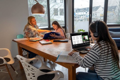 Homeschooling, during the lockdown in January 2021, mother helps her two daughters, at home,