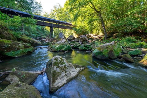 The Irrel Waterfalls, rapids in the lower reaches of the Prüm, covered wooden bridge for hikers,