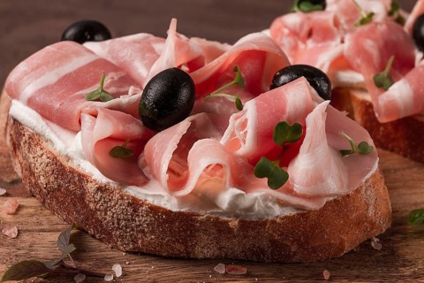 Breakfast, bacon and olives sandwich, on a cutting board, top view, close-up, no people