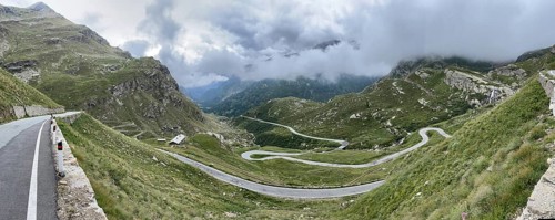 Panoramic photo of winding pass road to Alpine pass Colle del Col de Nivolet, low-hanging clouds in