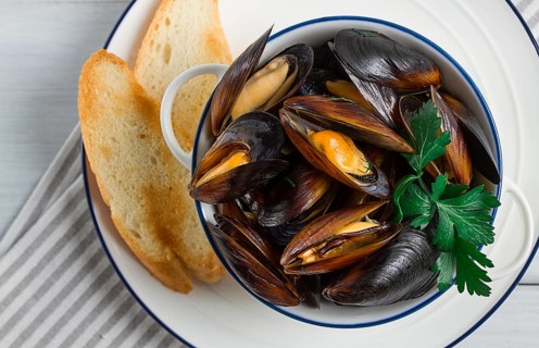 Fresh, Boiled mussels, Black Sea, with white bread, on a white wooden table, no people