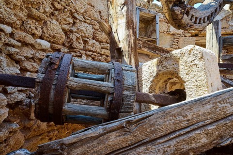 Close-up of an old wooden wheel in a dilapidated stone structure, windmill, ruin, near Lindos,