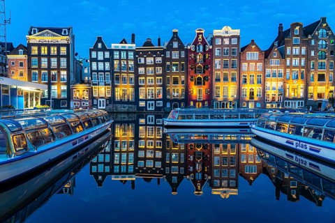 Canal houses on the Damrak, in the centre of the old town of Amsterdam, harbour, starting point of