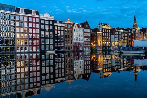 Canal houses on the Damrak, in the centre of the old town of Amsterdam, harbour, starting point of