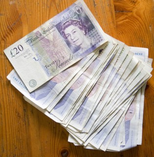 Â£20 sterling pound notes on a wooden table from above, UK