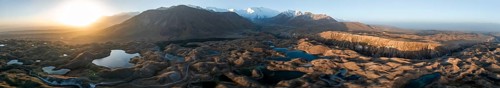 Panorama, White glaciated and snow-covered mountain peak Pik Lenin at sunrise, hilly landscape with