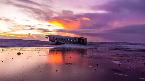 Beautiful aerial drone view at sunrise on crashed plane on frozen Solheimasandur beach in winter,