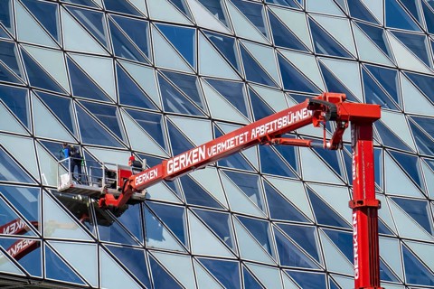 Building cleaners cleaning window panes, cleaning a facade, lorry working platform of the German