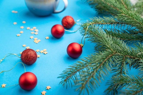 Christmas or New Year composition. Decorations, red balls, fir and spruce branches, cup of coffee,