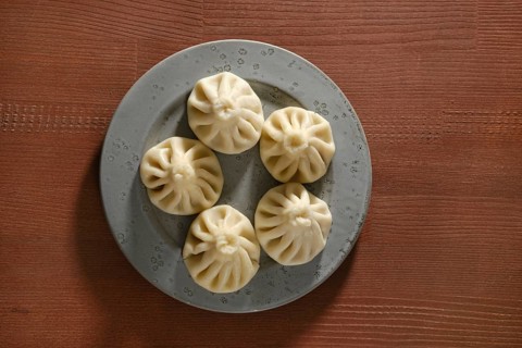 Overhead view of a plate with traditional Georgian dish khinkali stuffed with lamb of beef meat