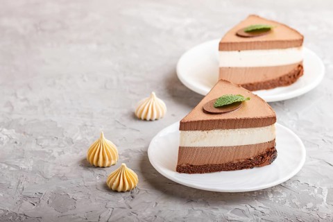 Cake with souffle milk chocolate cream on a gray concrete background. side view, close up, copy