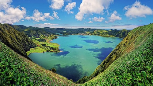 Panoramic view of the peaceful crater lake Lagoa Azul surrounded by lush crater rim, Lagoa Azul,