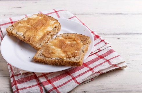 Sandwiches with pollock roe on a white plate, on a white wooden background with copy space