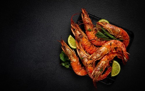 Langoustines, Australian, freshly frozen on ice, top view, lime and greens