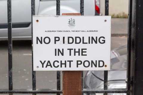 Funny sign saying No Piddling in the Yacht Pond paddling pool at Aldeburgh, Suffolk, England, UK