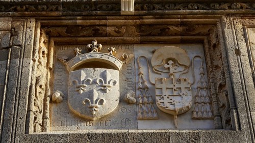 An elaborately designed stone relief with historical coats of arms and symbols from the Middle