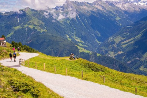 Hikers on a mountain path with impressive views of the surrounding mountains and valleys, Penken,