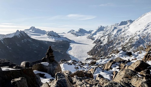 Cairn on the hiking trail to Ramoljoch with snow in autumn, mountain panorama and glacier, view of