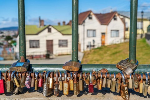 Love locks on a fence, residential houses behind, city of Punta Arenas, Patagonia, Chile, South