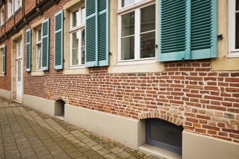 Windows with blue-green shutters on a brick house in Warendorf, Warendorf district, North