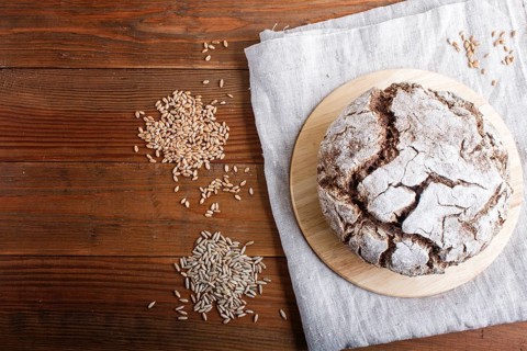 Yeast free homemade bread with whole rye and wheat grains on rustic wooden background. Top view,