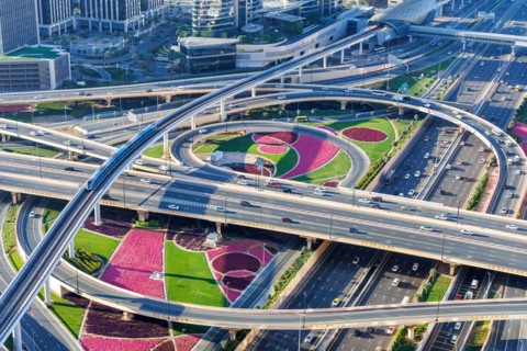 Intersection of Sheikh Zayed Road traffic on the road near the Burj Khalifa with Metro in Dubai,
